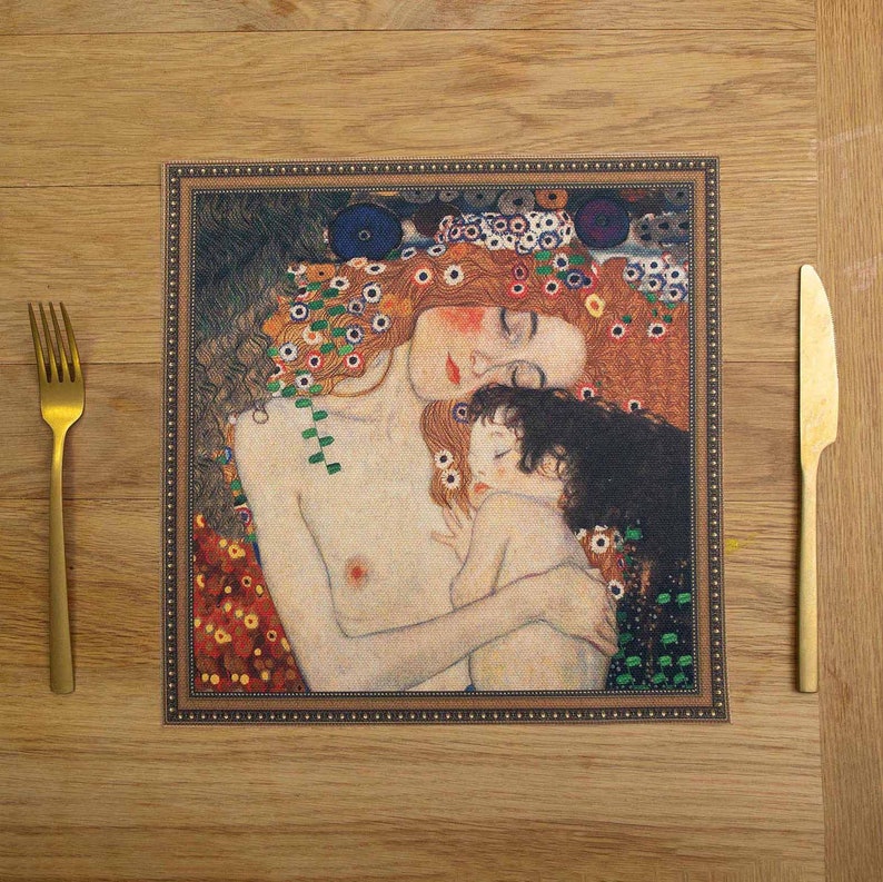 May include: A table placemat featuring a painting of a mother and child. The mother is lying down with her eyes closed, and the child is nestled in her arms. The painting is surrounded by a decorative frame.