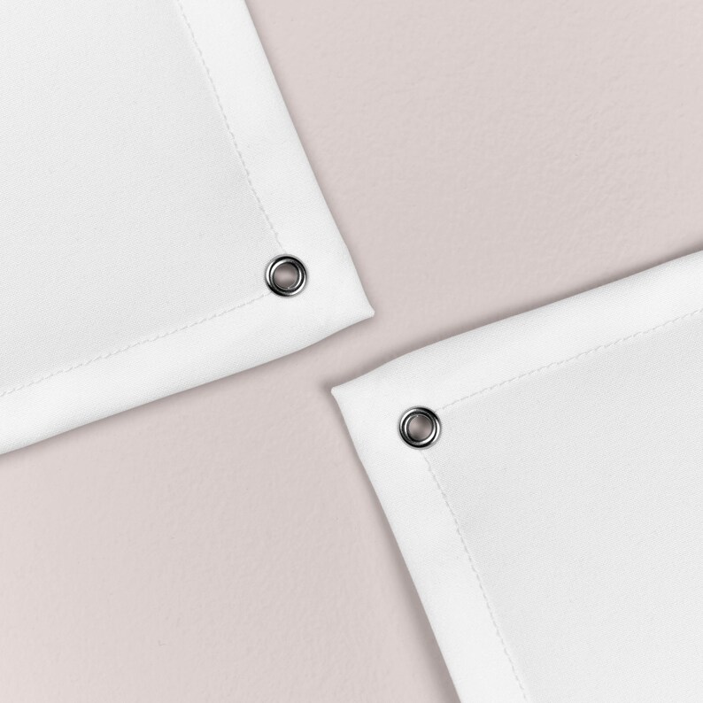 May include: Two white fabric shower curtains with silver grommets at the top corners.