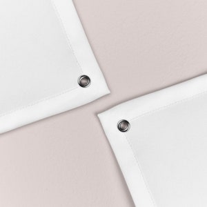 May include: Two white fabric shower curtains with silver eyelets at the top corners.