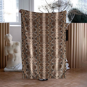 Pode incluir: Uma manta de arremesso marrom e bege com um padrão de pele de cobra.