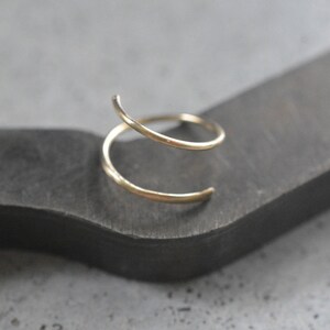 May include: A gold-toned double hoop earring with a simple, minimalist design.
