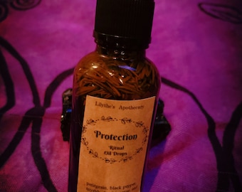May include: A brown glass bottle with a dropper top and a brown paper label that reads "Lilythe's Apothecary Protection Ritual Oil Drops petitgrain, black pepper, myrrh, frankincense, and rosemary herb".