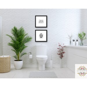 May include: Two framed prints with white text on a black background hang on a white brick wall in a bathroom. The top print says "Nice Butt" and the bottom print says "Let Yer Drip  Fatter Chip".