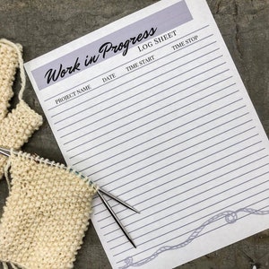 Könnte beinhalten: Nahaufnahme eines "Work in Progress Log Sheet" mit einem Strickstück und Stricknadeln. Das Log Sheet hat eine hellviolette Kopfzeile und ein graues Seildesign. Das Strickstück ist cremefarben.