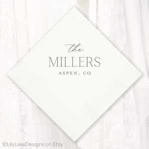 Puede incluir: Una servilleta cuadrada blanca con una superficie texturizada. El texto "The MILLERS ASPEN, CO" est&aacute; impreso en gris con fuente cursiva y sans-serif. La servilleta es probablemente para una boda o evento especial.