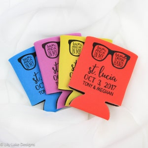 May include: Four colorful can coolers with a design of sunglasses and the text "sun, and a in my" and "sand drink hand". The red cooler has the text "st. lucia OCT 3, 2017 TONY & MEGHAN".