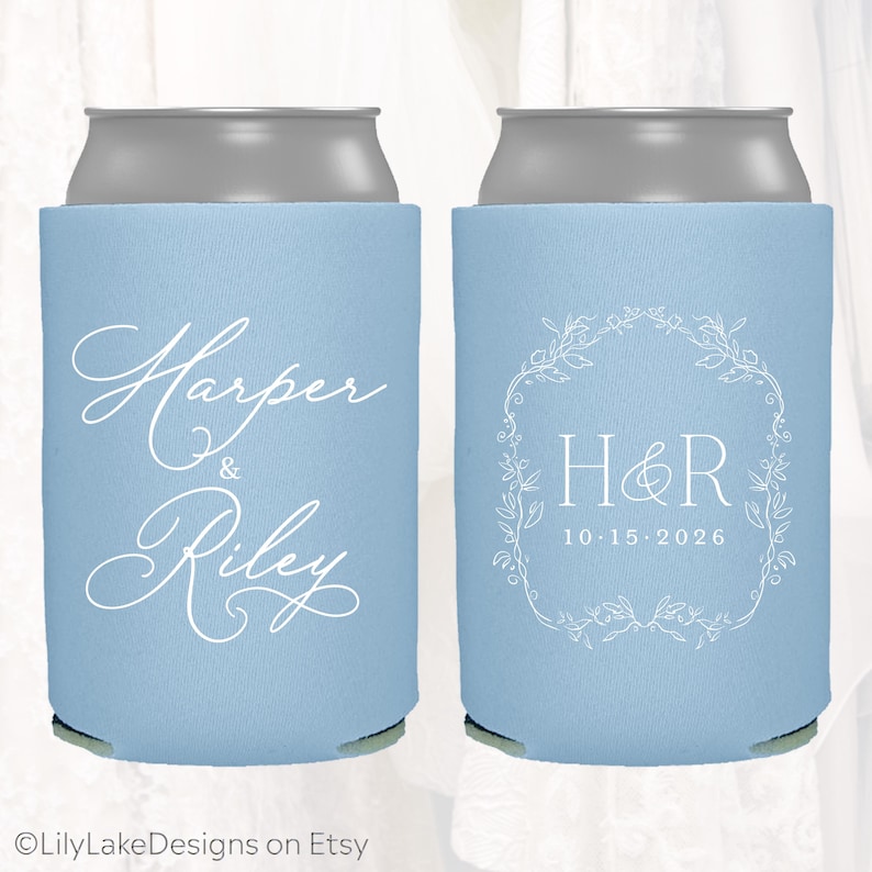 May include: Two light blue can coolers. One cooler has the names "Harper & Riley" in white script. The other has the initials "H&R" inside a white floral wreath, with the date "10.15.2026" below. The Etsy shop name "LilyLakeDesigns" is at the bottom.