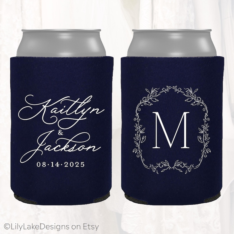 May include: Navy blue can coolers with white text. One cooler features the names "Kaitlyn & Jackson" and the date "08.14.2025". The other has a white floral wreath around the letter "M".