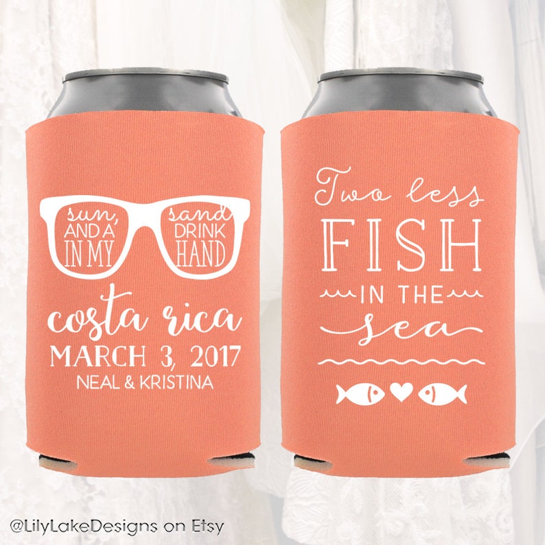 May include: Two coral-colored can coolers with white text. One cooler says "sun, and a drink in my hand, costa rica, march 3, 2017, neal & kristina". The other cooler says "two less fish in the sea" with two fish icons and a heart.