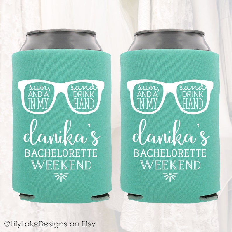 K&ouml;nnte beinhalten: Zwei t&uuml;rkisblaue Getr&auml;nkedosenk&uuml;hler mit wei&szlig;em Text und einer Grafik von Sonnenbrillen. Der Text lautet "sun, and a in my, sand drink hand" und "danika's bachelorette weekend".