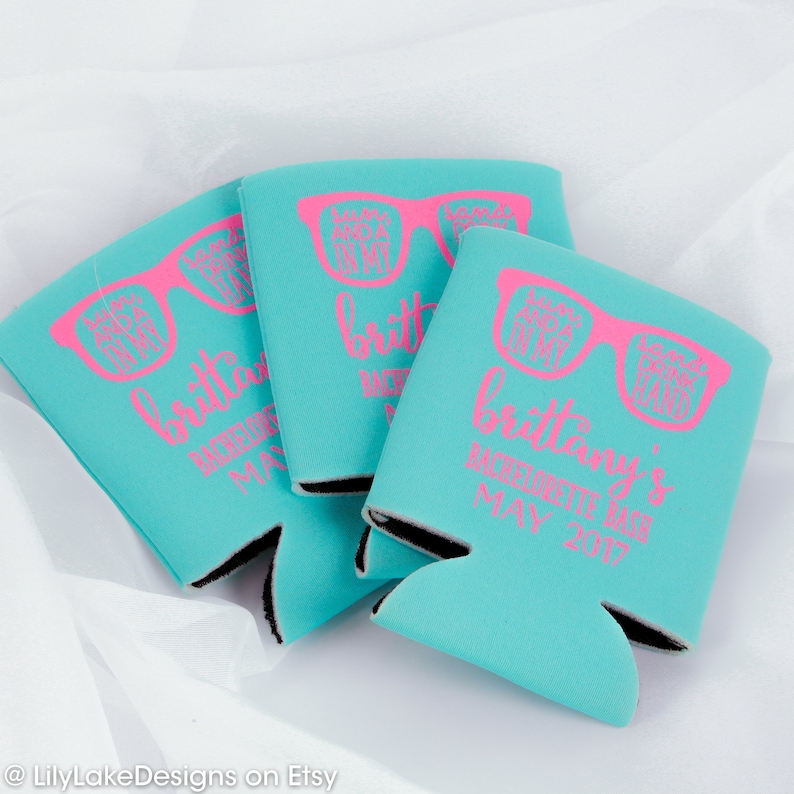 K&ouml;nnte beinhalten: Drei t&uuml;rkisblaue Getr&auml;nkedosenk&uuml;hler mit schwarzem Besatz. Jeder K&uuml;hler hat ein rosafarbenes Design mit Sonnenbrillen, auf deren Gl&auml;sern der Text "Bride Tribe" und "Let's Get Lit" steht. Der Text "Brittany's Bachelorette Bash May 2017" ist auf den K&uuml;hler gedruckt.