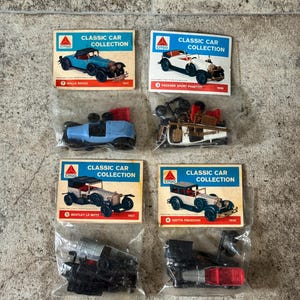 May include: A collection of vintage toy cars, each in a clear plastic bag with a card. The cards read "Classic Car Collection" and feature illustrations of the cars, including a Rolls Royce, Packard, Bentley, and Isotta Fraschini.