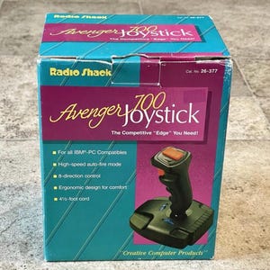 May include: A black and orange Radio Shack Avenger 700 joystick for IBM-PC compatible computers. The box features the text "The Competitive "Edge" You Need!" and lists features such as high-speed auto-fire mode, 8-direction control, ergonomic design for comfort, and a 4 1/2-foot cord.