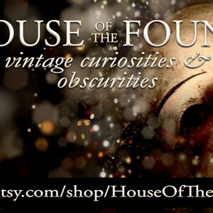 K&ouml;nnte beinhalten: Das Gesicht einer antiken Puppe mit einer rissigen Porzellanmaske vor einem Hintergrund aus funkelnden Lichtern. Der Text "HOUSE OF THE FOUND vintage curiosities & obscurities" wird &uuml;ber dem Gesicht der Puppe angezeigt. Der Text "www.etsy.com/shop/HouseOfTheFound" wird unter dem Gesicht der Puppe angezeigt.