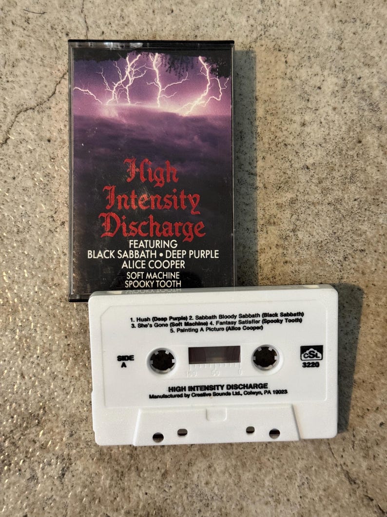 May include: A vintage cassette tape for "High Intensity Discharge" featuring Black Sabbath, Deep Purple, and Alice Cooper. The cover has a purple lightning storm design. The white cassette tape lists song titles.
