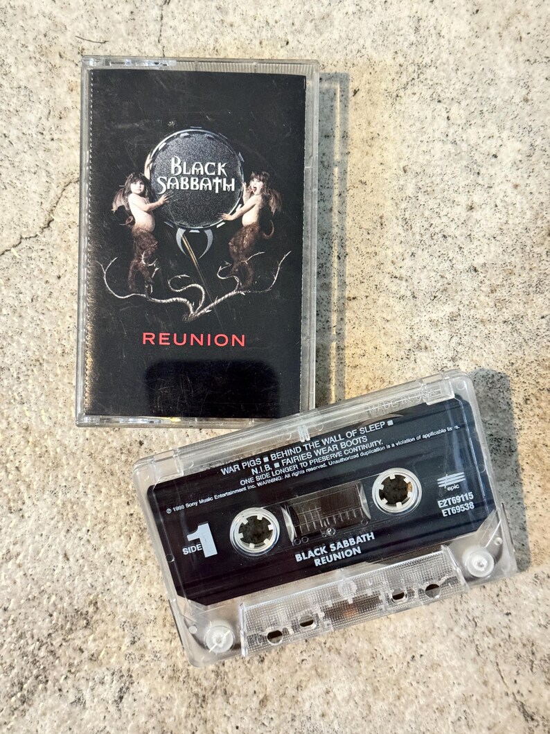 May include: Two vintage Black Sabbath "Reunion" cassette tapes. The cassette cases are clear, and the labels are black. The album cover features the band's name and the word "Reunion" in white text, with a graphic of two figures.