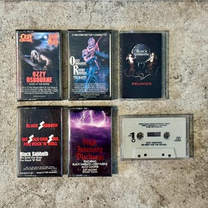 May include: A selection of six vintage cassette tapes featuring rock and heavy metal artists. The tapes include albums by Ozzy Osbourne, Black Sabbath, and a tribute album. The cassette cases are black and white with album art.