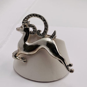 Sterling silver deer brooch with a pin back closure.