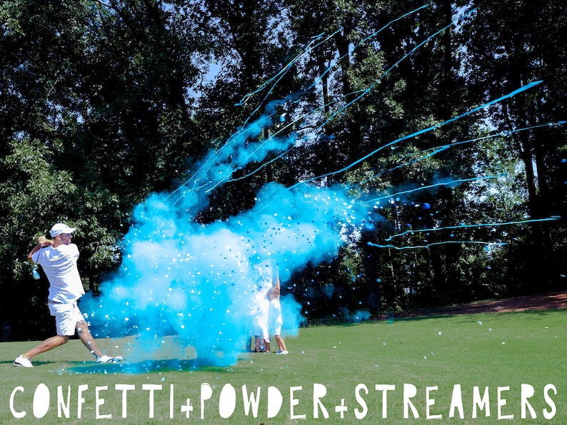 May include: A person swings a golf club, releasing blue confetti powder and streamers in the air. The powder creates a large blue cloud, and the streamers are visible against the green grass and trees in the background. The text "CONFETTI + POWDER + STREAMERS" is printed at the bottom of the image.