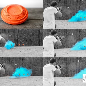 May include: A man shoots a shotgun at a clay pigeon target. The target explodes in a cloud of blue smoke. The image is in black and white except for the blue smoke and the orange clay pigeon target.