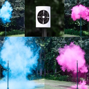 May include: A gender reveal party setup with two smoke bombs, one blue and one pink, exploding from a target stand. The target stand has a black and white bullseye target.