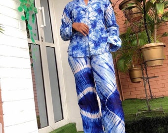 May include: A blue and white tie-dye print pantsuit with a long-sleeved button-up shirt and wide-leg pants.
