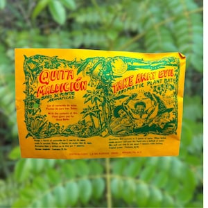 May include: Yellow packet with green and black illustrations of a man and a witch. The packet is labeled "Quita Maldicion" and "Take Away Evil Aromatic Plant Bath".
