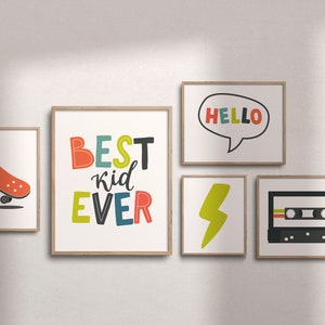 K&ouml;nnte beinhalten: F&uuml;nf gerahmte Drucke mit Retro-Thema. Die Drucke zeigen ein Skateboard, die Worte "BEST kid EVER" in bunten Buchstaben, einen Blitz, das Wort "HELLO" in einer Sprechblase und ein Kassettenband.