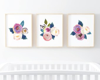 May include: Three framed watercolor paintings of floral bouquets with pink, purple, and white flowers. The flowers are painted in a loose, abstract style. The frames are simple and wooden.