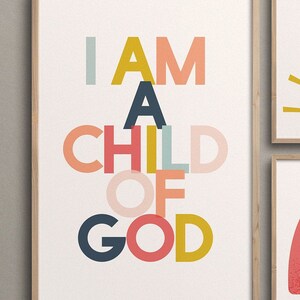 May include: A framed print with the text "I AM A CHILD OF GOD" in colorful, overlapping letters. The letters are in shades of pink, red, yellow, blue, and green.