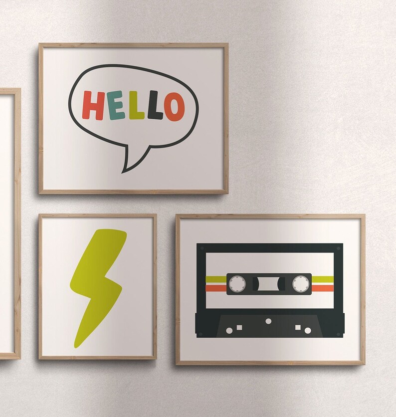 K&ouml;nnte beinhalten: Drei gerahmte Drucke an einer wei&szlig;en Wand. Der erste Druck zeigt eine Sprechblase mit dem Wort "HELLO" in bunten Buchstaben. Der zweite Druck zeigt einen gelben Blitz. Der dritte Druck zeigt ein schwarzes Kassettenband mit bunten Streifen.