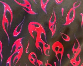 May include: Black fabric with a repeating pattern of pink and purple flames. The flames are stylized and have a glossy finish.