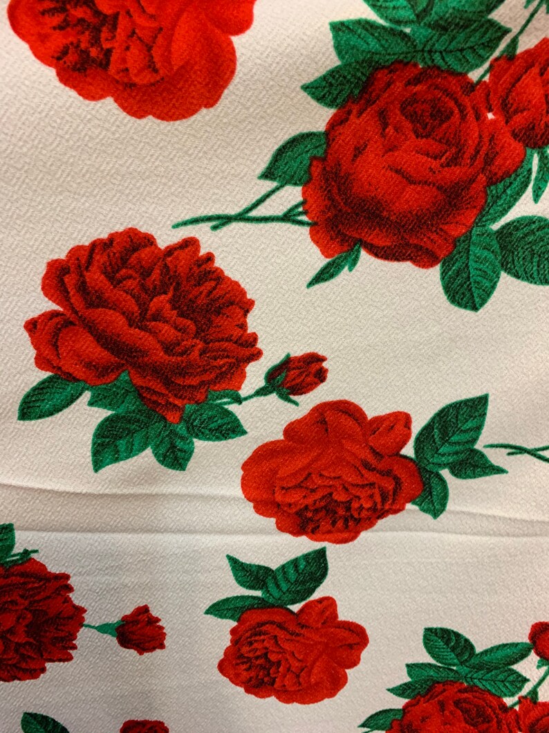 White 4 way stretch poly liverpool fabric with red all over roses green leaves design sold by the yard