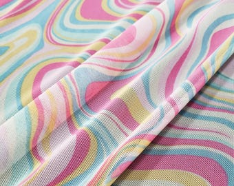 May include: A close-up of a white mesh fabric with a swirling pattern in shades of pink, yellow, and blue.