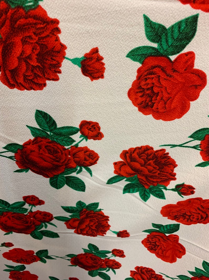 White 4 way stretch poly liverpool fabric with red all over roses green leaves design sold by the yard