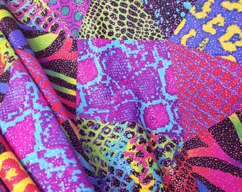 May include: A colorful fabric with a patchwork design featuring various animal prints, including snake, leopard, and zebra. The fabric is made of a shiny material with a glittery finish.
