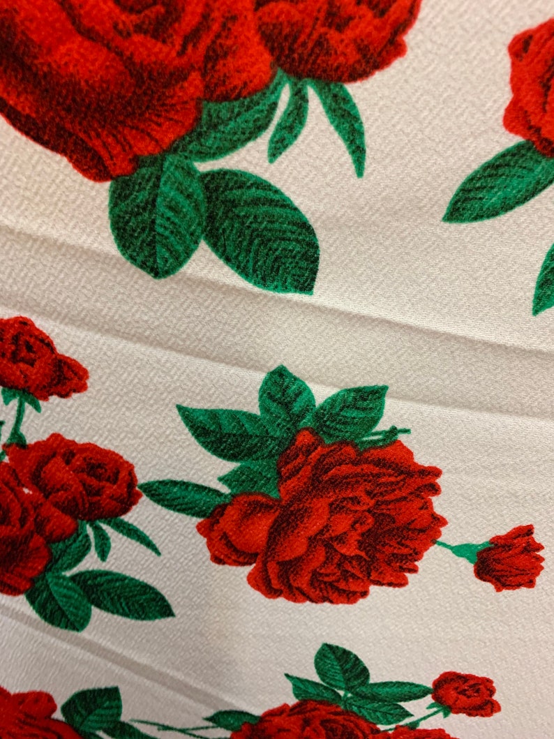 White 4 way stretch poly liverpool fabric with red all over roses green leaves design sold by the yard