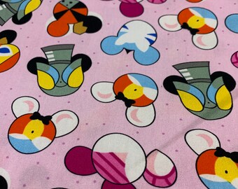 Puede incluir: Tela rosa con un patrón repetido de personajes de dibujos animados con sombreros, ojos y pajaritas de diferentes colores. Los personajes tienen orejas grandes y están sobre un fondo de pequeños puntos blancos.