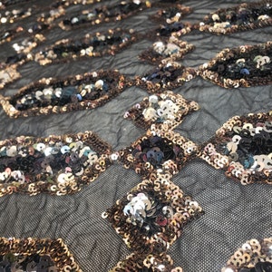 May include: Black mesh fabric with a geometric pattern of iridescent sequins in gold, silver, and black.