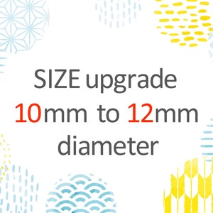 以下が含まれることがあります： 青と黄色の模様の円が描かれた白い背景。中央に「SIZE upgrade 10mm to 12mm diameter」というテキストがあります。