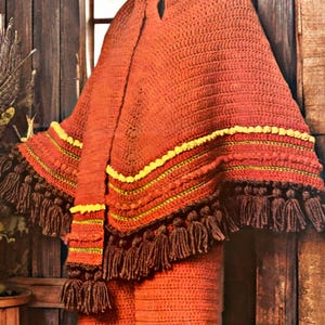 May include: A rust-colored crochet poncho with a matching scarf and pants. The poncho has yellow and green trim and brown tassels. The text "Esther's patterns" is visible at the bottom.