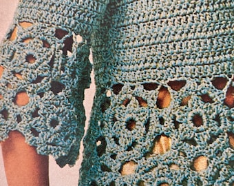 Könnte beinhalten: Nahaufnahme eines türkisfarbenen Häkeltops mit Lochmuster an Ärmeln und Saum. Das Kleidungsstück hat ein strukturiertes Stichmuster und einen gewellten Rand. Der Text "Esther's patterns" ist unten sichtbar.