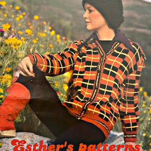 May include: A vintage-style, zip-up sweater with a bold orange, black, and yellow checkered pattern. The sweater is worn with black pants and a black hat. The text "Esther's patterns" is visible.