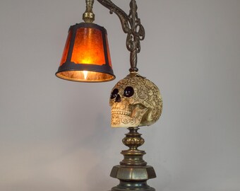 Carved skull accent lamp on vintage heavy brass base and mica shade.
