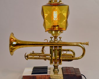 Vintage cornet accent lamp on vintage piano keys..