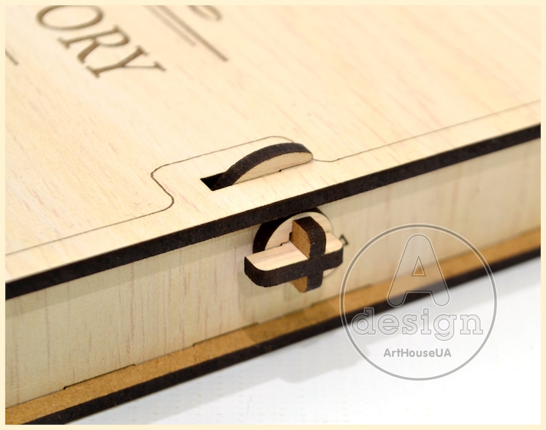 May include: A wooden box with a latch and the word "STORY" engraved on the top. The box is made of light wood with a dark brown trim. The box is closed and the latch is in the closed position.