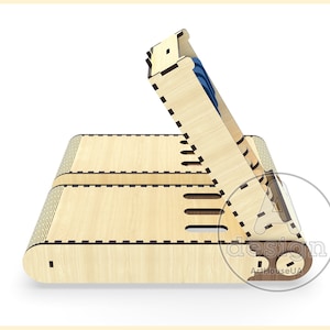 May include: A wooden box with a hinged lid, designed to hold small items. The box is made of light wood with a natural finish and has a decorative pattern on the front. The lid is open and reveals a small compartment inside.