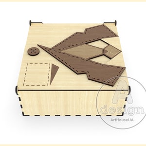 May include: A wooden box with a decorative design of a shirt and tie. The box is made of light wood with a brown stain. The design is cut out of the wood and has a dark brown finish. The box has a small button on the top.