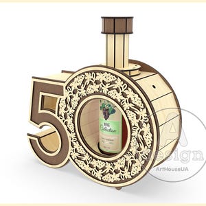 May include: Wooden wine bottle holder shaped like the number 50, with a decorative grapevine design and a cutout for a wine bottle. The holder is made of light brown wood and has a dark brown trim.