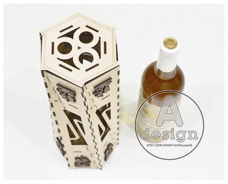 May include: A wooden wine bottle holder with a hexagonal top and intricate cutouts. The holder is made of light brown wood and has a dark brown stain. The holder is designed to hold a standard-sized wine bottle.
